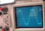 Oscilloscope readout of an amplifier output. This shows a 1 KHz sine wave clipping into 5 ohms. 10V/division.
